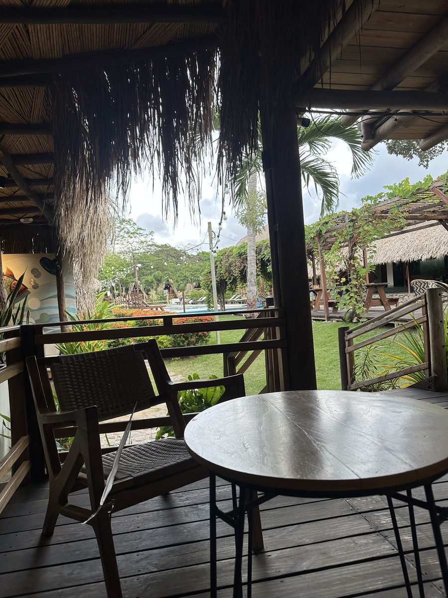 Tiki Hut Hostel — Terrasse mit Pool unter Strohdächern