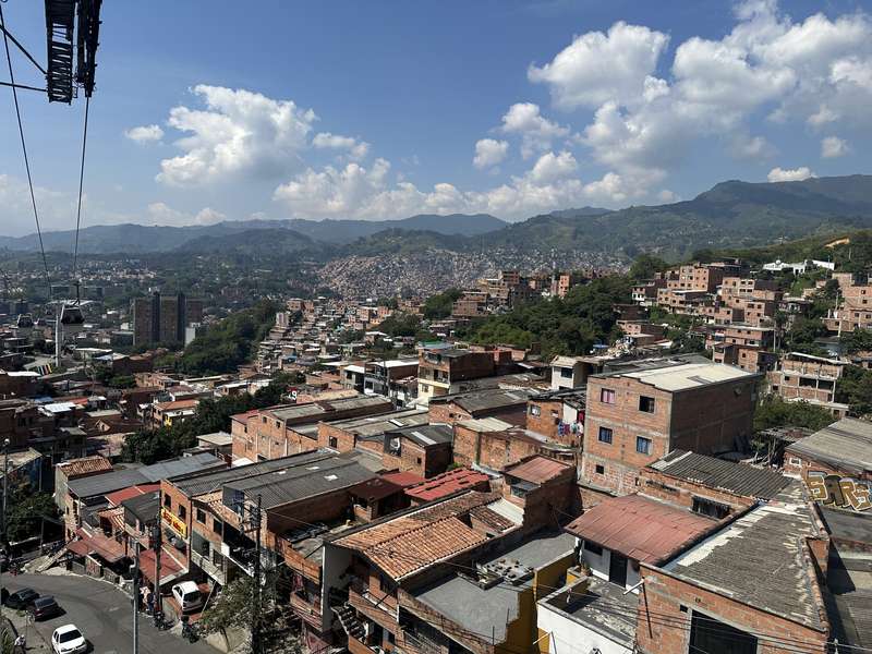 Panorama Comunas — rote Backsteindächer, Berge am Horizont