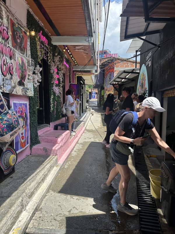 Enge Gasse mit Murals und Neon-Schildern